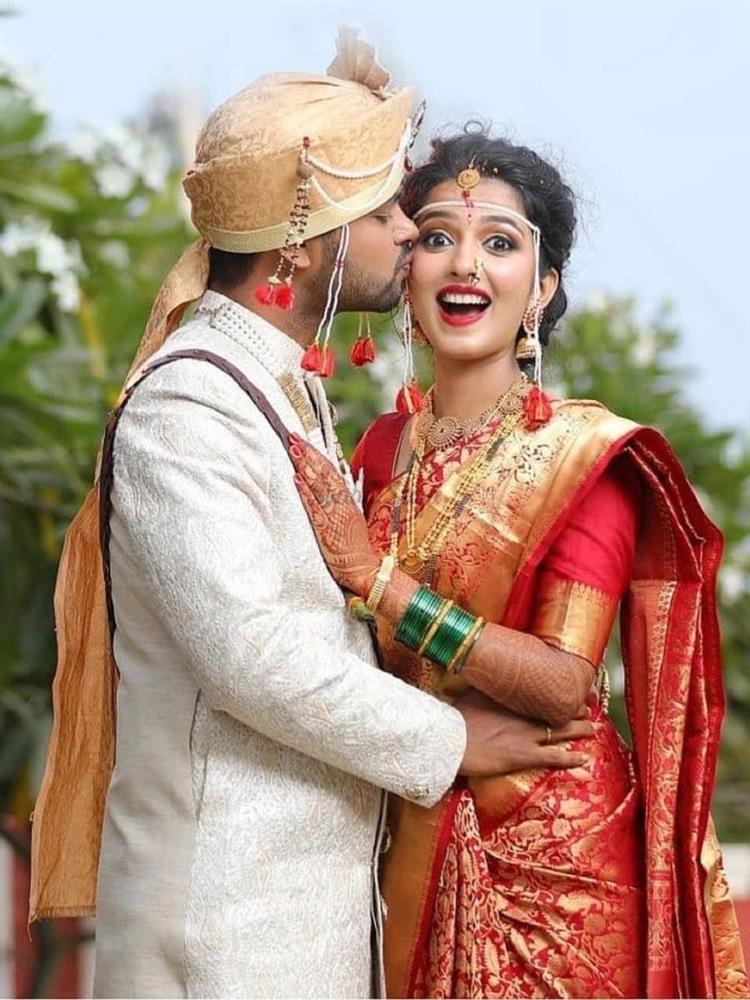 Capture the couple in traditional Marathi attire, with the bride in a Nauvari saree and the groom in a Dhoti-Kurta, posing regally as if they were Maharashtrian royalty.